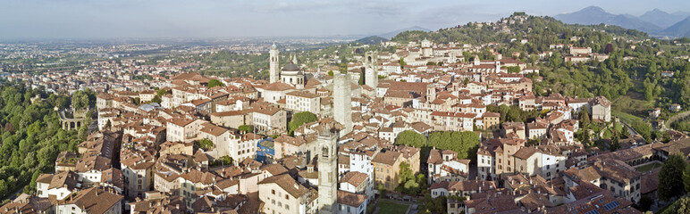 Fototapeta na wymiar Drone aerial view of Bergamo - Old city. One of the beautiful city in Italy. Landscape on the city center, its historical buildings and towers during a wonderful blu day