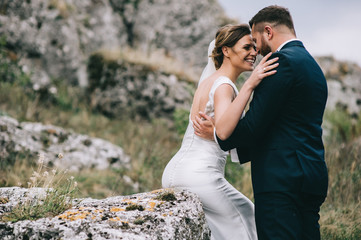 portrait of a girl and couples looking for a wedding dress, a pink dress flying with a wreath of flowers on her head on a background tsvetu chicago garden and the blue sky, and they hug and pose