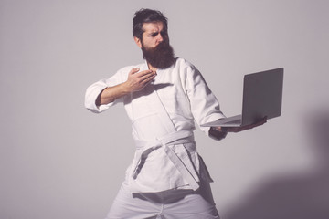 bearded serious karate man in kimono with laptop © Volodymyr