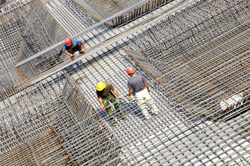 worker in the construction site making reinforcement metal framework for concrete pouring