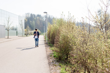 Obraz premium Junger Mann mit Handy auf Straße