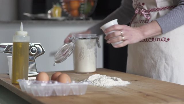Housewife puts the flour on the cutting board to make the dough