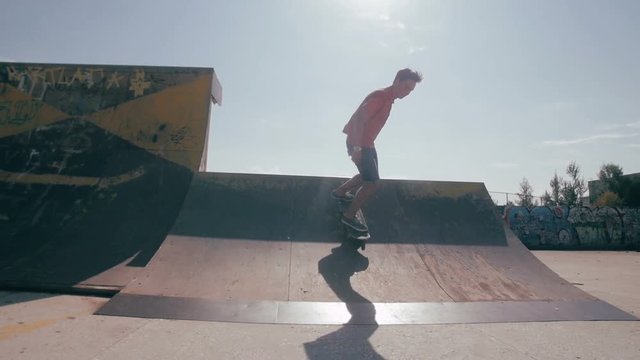 The skateboardist is skating in the ramp in the skateboarding park.HD