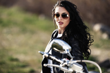 Naklejka na ściany i meble Beautiful brunette woman with a classic motorcycle (cinema bleach bypass effect)