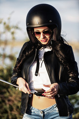 Beautiful brunette woman with a classic motorcycle (cinema bleach bypass effect)