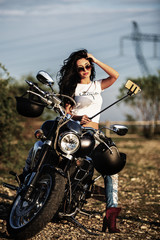 Obraz na płótnie Canvas Beautiful brunette woman with a classic motorcycle (cinema bleach bypass effect)