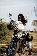 Fototapeta na wymiar Beautiful brunette woman with a classic motorcycle (cinema bleach bypass effect)