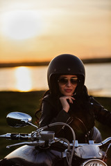 Beautiful brunette woman with a classic motorcycle (cinema bleach bypass effect)