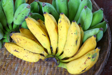 Bunch of yellow and green banana on bamboo weave