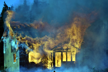 Fototapeta na wymiar House completely engulfed in flames.