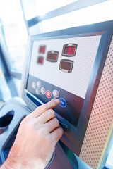 Close-up partial view of hand and interface of fitness machine in gym