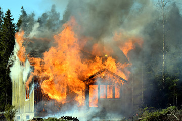 Home on fire as the flames burst through the windows, door and roof of the house