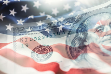 USA flag and American dollars. American flag blowing in the  wind and 100 dollars banknotes in the background. - obrazy, fototapety, plakaty