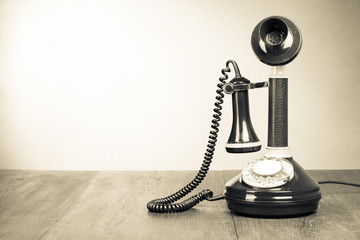 Old retro telephone on table vintage style sepia photo