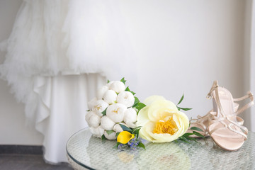 Wedding bouquet and bride shoes, on background bride dress