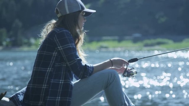 girl sitting on a log fishing