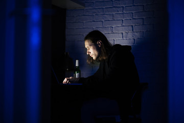 Concentrated man using laptop computer at home indoors