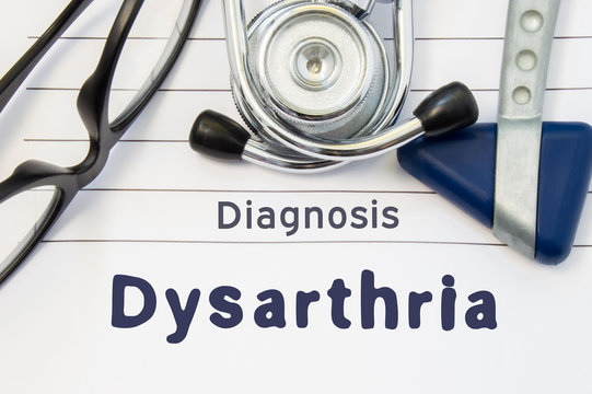 Neurological diagnosis of Dysarthria. Neurological hammer, stethoscope and doctor's glasses lie on doctor workplace on sheet of notebook, labeled with the title of medical diagnosis of Dysarthria