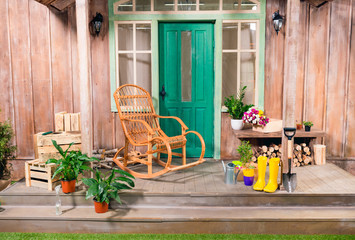 Potted plants and rocking chair on porch with gardening tools