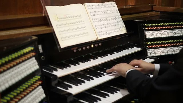 Close up view of organist playing pipe organ.