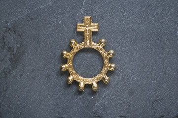Golden Finger Rosary on top of stone surface