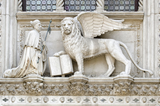 Detail of the Porta della Carta entrance to the Doge's Palace in Venice, Italy, depicting Doge Francesco Foscari kneeling before the Lion of St. Mark, the historical symbol of the Venetian Republic