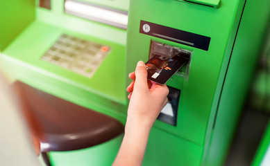 Hand of a man with a credit card, using an ATM. Man using an atm machine with his credit card.