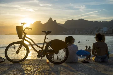 Raamstickers Silhouettes gathered to watch the sunset in Rio de Janeiro, Brazil © lazyllama