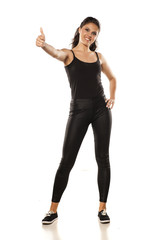 Fototapeta premium Whole figure of a young woman in tights and blouse showing thumbs up