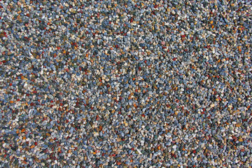 Texture of lots of small colorful pebbles on the ground.   