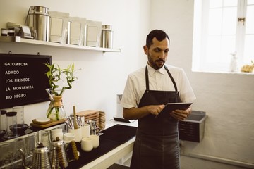 Barista using tablet while standing