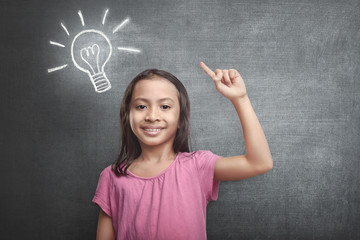 Cheerful asian kid with bright idea symbol above her head