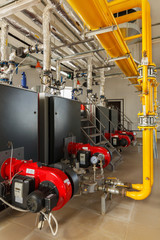 Interior of industrial gas boiler house with many pipes and boilers