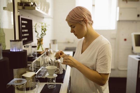 Female barista preparing filter funnel