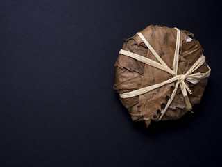 French banon cheese wrapped in chestnut leaves isolated on black background