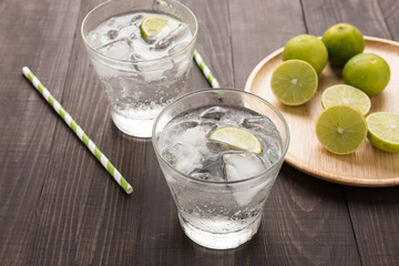 Fresh cocktail with soda, lime on a wooden background