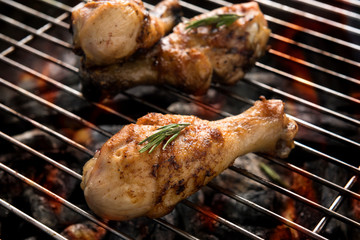 Grilled chicken drumstick over flames on a barbecue