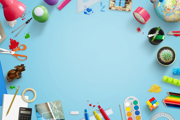 Back to school background image with free space for text ind middle. Stationery, toys, drawing and learning accessories beside.Top view of blue work desk.