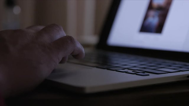 close up of hands on scrolling on laptop