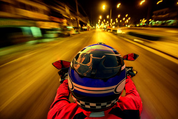 Man riding motorcycle on night road with speed for motion blur