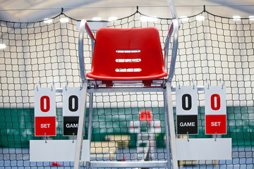 Umpire chair with scoreboard on a tennis court before the game.