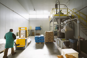 Man working in a factory pushing a pallet truck