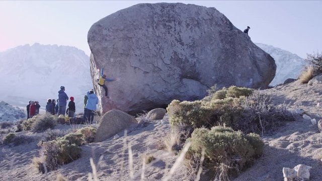 man makes hard moves on boulder problem