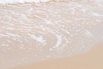 Ocean waves exhausted on the beach.