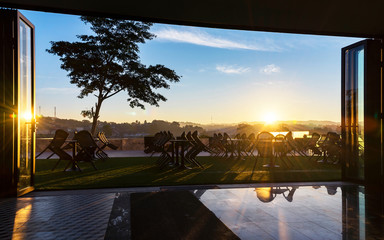 Beautiful Silhouette tree with chair around luxury swimming pool.