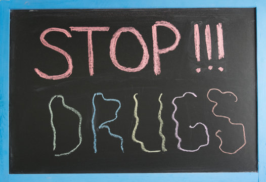 Conceptual stop sign narcotics colored chalk on a slate with a blue frame