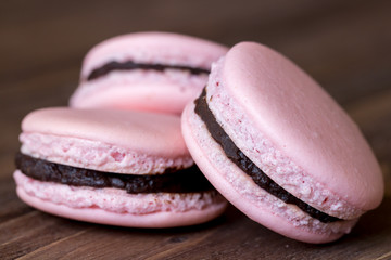 Three french desert pink macaron cakes macro on wooden background
