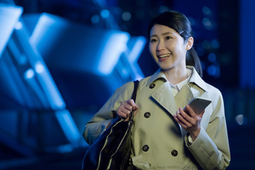 携帯電話を使うビジネスウーマン、道案内、ナビ、アプリ