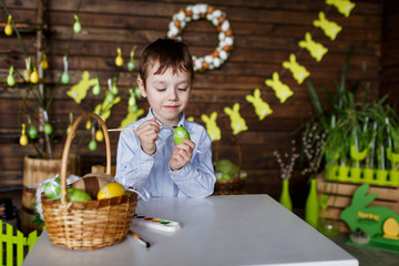 Boy with colored eggs preparing for easter, painting eggs