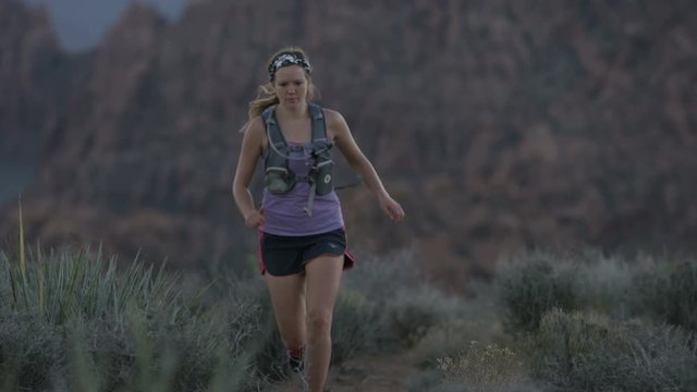 slow motion of girl trail running in desert